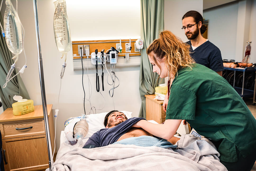 student nurse helping patient on bed